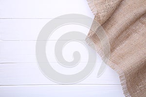 Natural sackcloth on white wooden background. Canvas on white wooden table