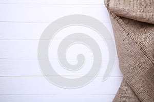 Natural sackcloth on white wooden background. Canvas on white wooden table