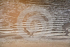 Natural sand patterns in beach at low tide.