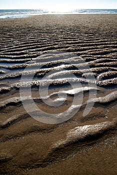 Natural sand patterns in beach at low tide.