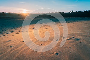 Natural sand plain with rising morning sun and atmospheric grazing light