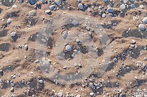 Natural sandy and pebble stone background on summer sunny day