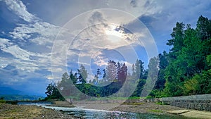 natural scenery, river between pine forests and blue sky full of clouds