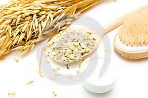 Natural skin cleansing product for body detox. Oat flakes, cream, oat milk, body scrub brush, white table, home spa