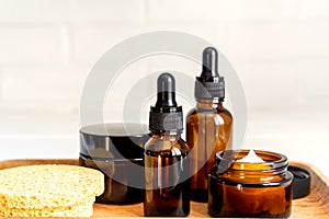 Natural skincare products in glass bottles. Serum and cream for facial skin. Herbal mineral cosmetic, vitamin body oil on wooden
