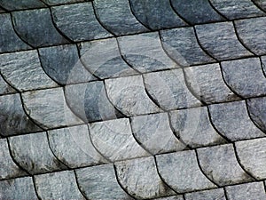 Natural slate mineral tile covered roof detail in fish scale pattern