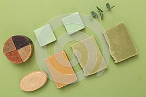 Natural soap of different shapes and a sprig of eucalyptus on a green background. Undertone. Self-care photo