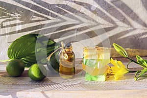 Natural soap, limes, aromatic oil for making a bath on a wooden table, spa, home cosmetics for body care