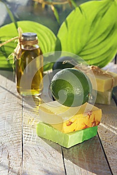 Natural soap, limes, aromatic oil for making a bath on a wooden table, spa, home cosmetics for body care