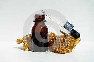 Natural soap and serum for skin care with honey and honeycombs on a white background. honey oil in a small jar.