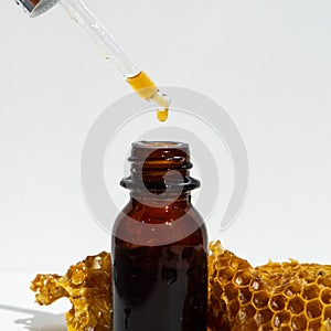 Natural soap and serum for skin care with honey and honeycombs on a white background. honey oil in a small jar.