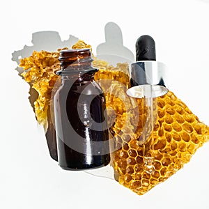 Natural soap and serum for skin care with honey and honeycombs on a white background. honey oil in a small jar.