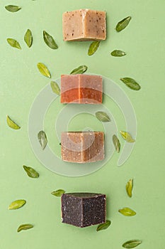 Natural soap triangular pieces on green background. Vertical format. Organic