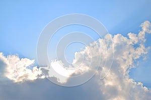 Natural soft clouds pattern and sunshine ray on blue sky background