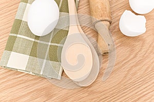 natural solid wood kitchen tools and table napkin with eggs on a wooden background