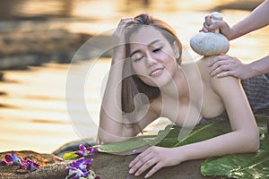 Natural Spa,Beautiful Woman relaxing in round outdoor bath with tropical flowers