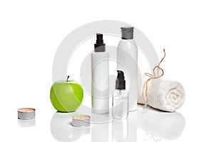 Natural spa beauty treatment cleansing products with apple on white background.