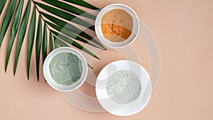 Natural SPA cosmetics for skincare, body and hair care concept. Top view facial clay masks and tropical leaf