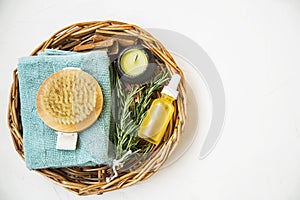 Natural spa skincare and beauty products. Rosemary herb, oil bottle, body brush and towel, top view of spa products with natural