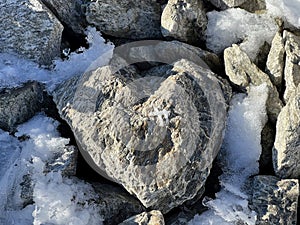 A natural stone heart in the fresh snow of the Swiss mountain massif of the Abula Alps photo