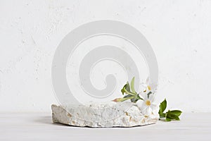 Natural stone podium with orchid flowers for cosmetics product presentation