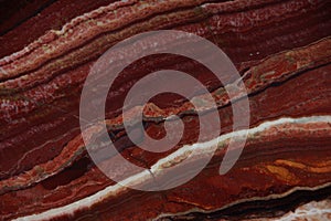 Natural stone of red color with an interesting pattern called Onice Fantastico photo