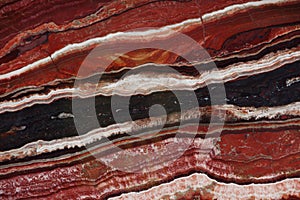 Natural stone of red color with a pattern called Onice Fantastico photo