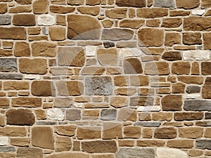 Natural stone rustic wall with large rocks of three colors: white,brown and grey