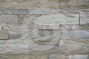 Natural stone, smooth linear masonry, gray relief texture. The wall is made of stone, the surface is textured, color