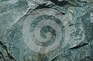 Natural stone texture with a natural pattern, cracks and irregularities. Soft focus, shallow depth of field