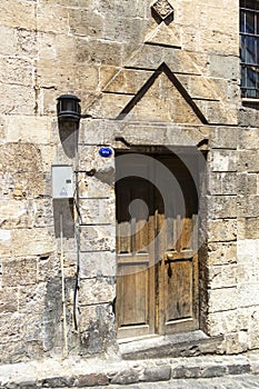 Natural stone wall, metal material garden gate in closed position.