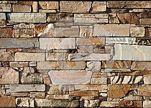 Natural stone wall texture background. These stone bricks range in color from white and pink to brown
