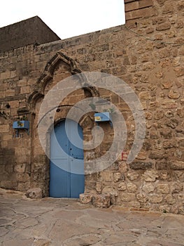 natural stone wall  traditional construction techniques  garden gate made of ferrous metal and painted blue