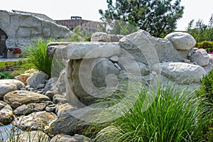 Natural stone waterfall cascade in pond design.