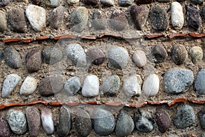 Natural stones and roof tiles rows on an old wall