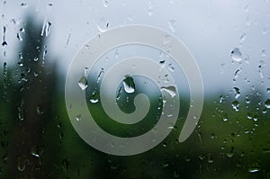 Natural summer background - raindrops on the window glass, close up.