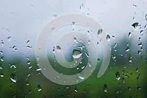 Natural summer background - raindrops on the window glass, close up.