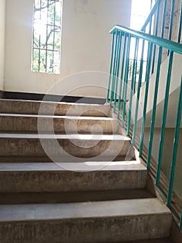 Sunlight streaming through window creating geometric shadow patterns on staircase floor