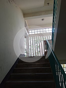 Sunlight streaming through window creating geometric shadow patterns on staircase floor