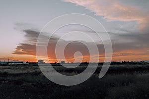 Natural Sunset Sunrise Over Field Or Meadow. Bright Dramatic Sky And Dark Ground. Countryside Landscape Under Scenic Colorful Sky