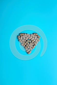 Natural Supplements in the form of a heart on a light background. The concept of alternative medicine