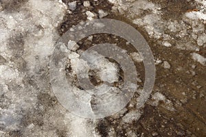 Natural texture of white ice and snea on wet brown sand