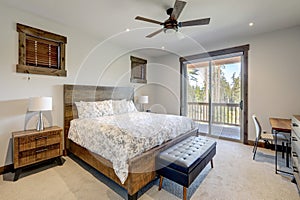 Natural tones cozy bedroom interior with grey bedding, beige carpet and lots of windows