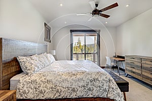 Natural tones cozy bedroom interior with grey bedding, beige carpet and lots of windows