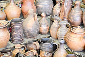 Natural traditional clay pottery beautiful old kitchen appliances, dishes, jugs, vases, pots, mugs. The background