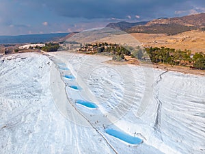 Natural travertine pools blue water in Pamukkale Turkey drone aerial top view