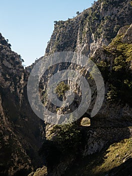 Natural tunnel on hiking trail path route Senda del Cares valley canyon in Picos de Europa mountains Leon Asturias Spain photo