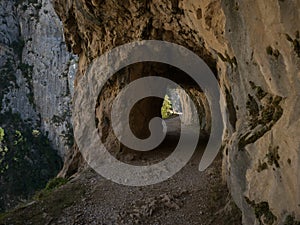 Natural tunnel on hiking trail path route Senda del Cares valley canyon in Picos de Europa mountains Leon Asturias Spain photo