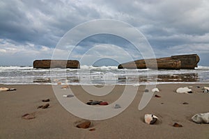 Natural view of small stones on a sandy beach under a cloudy sky background