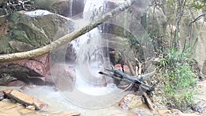 Natural View Of A Small Waterfall, Flowing From Large Natural Rocks